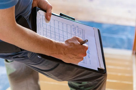 Home Inspector Filling Out A Check List On A Clipboard