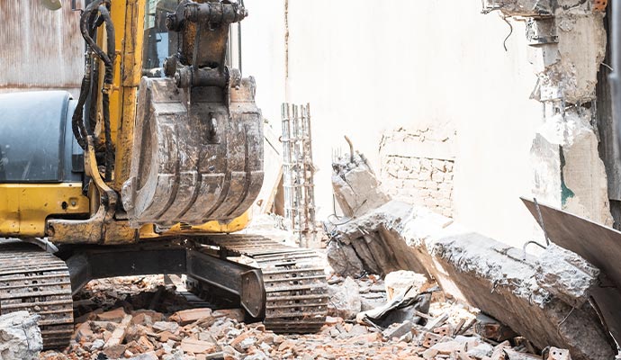 yellow excavator is on duty for pulling down the buildings selective demolition